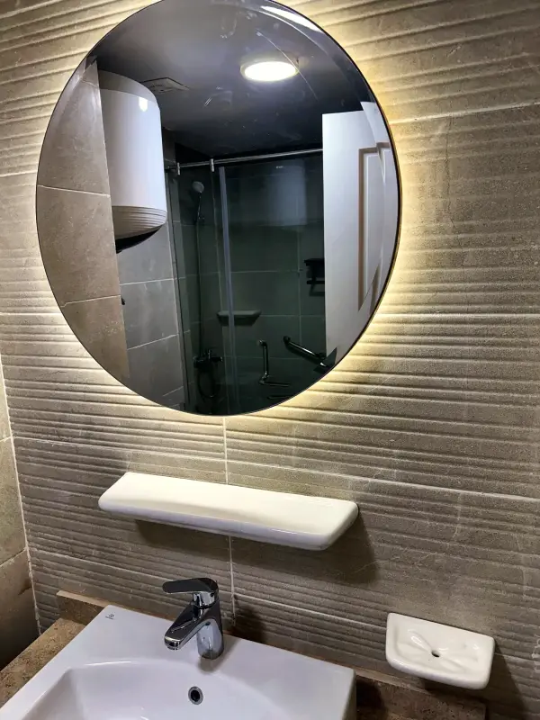 Basin and backlit round mirror