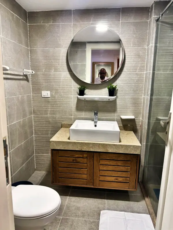 Bathroom with walk-in shower and round mirror