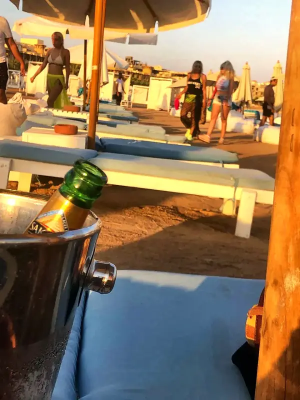 A cooler and glasses set out beside the loungers
