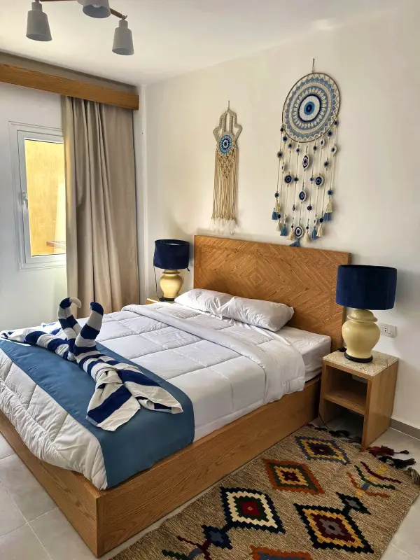 Double bed with bedside lamps and patterned rug