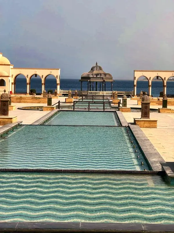 The long pool running out to a domed pavilion and the sea